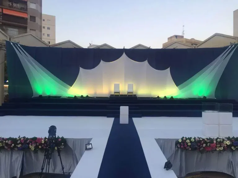 Escenario decorado con luces verdes y blancas, creando un ambiente elegante y festivo.