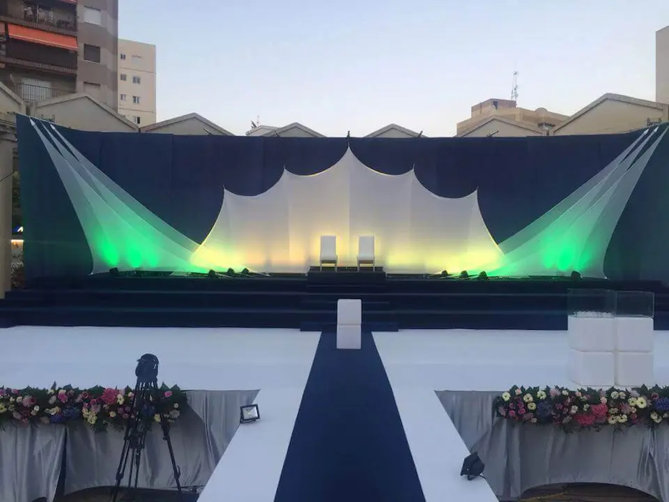 Escenario decorado con luces verdes y blancas, creando un ambiente elegante y festivo.