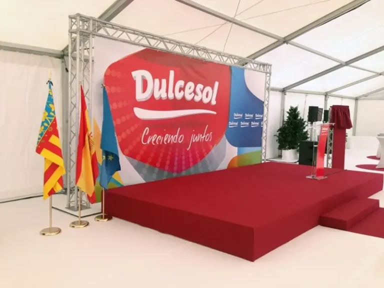 Escenario amplio con banderas y un gran banner del evento corporativo de la empresa Dulcesol.