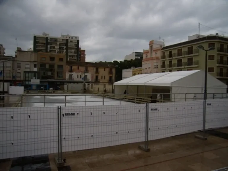 Carpa blanca en un entorno urbano, rodeada de vallas que exhiben el logo de Ruano Group.