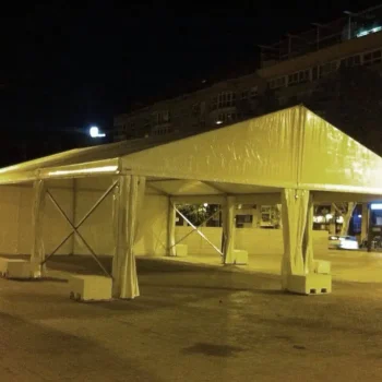 Carpa blanca de gran tamaño montada en la vía pública, con un entorno despejado a su alrededor.