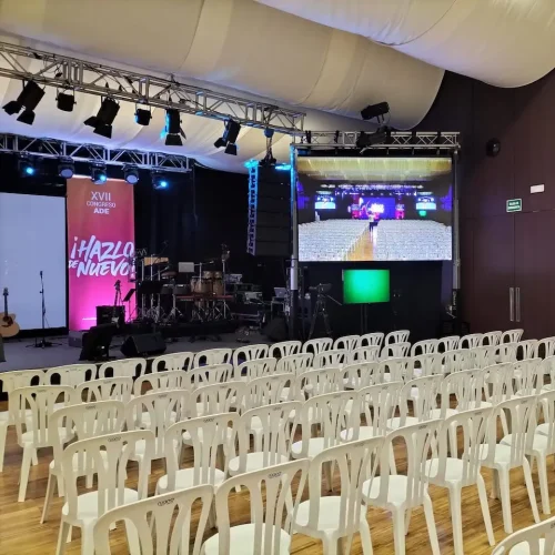 Sala amplia con sillas blancas dispuestas y una pantalla grande al frente, lista para el Congreso ADE.