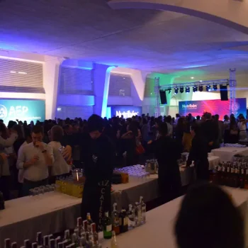 Multitud de personas reunidas en un congreso, disfrutando de un ambiente festivo y de interacción social.