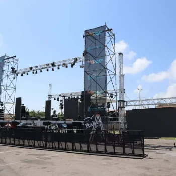 Escenario al aire libre preparado para un concierto, con luces y altavoces dispuestos para la actuación.