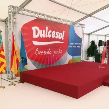 Escenario amplio con banderas y un gran banner del evento corporativo de la empresa Dulcesol.