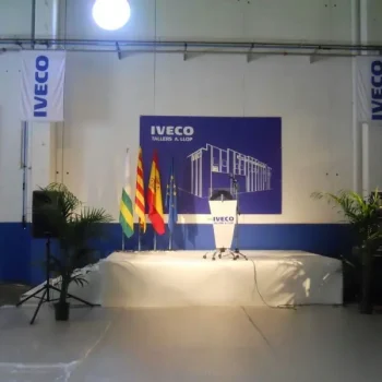 Escenario con podio y banderas en un gran edificio durante un evento corporativo de Iveco.