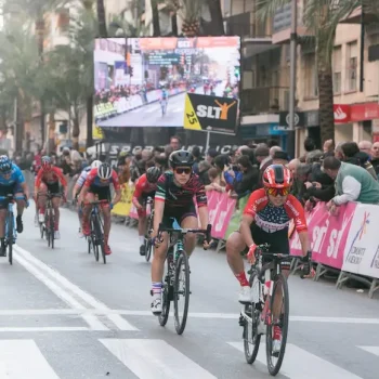 Varios ciclistas pedaleando juntos en una calle, celebrando un evento deportivo.