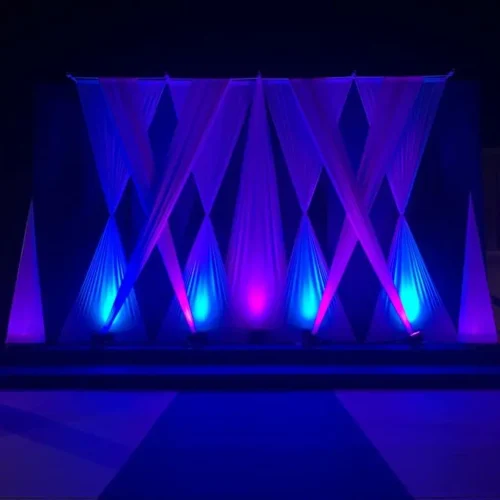 Escenario iluminado con luces moradas y azules durante el evento Festers en Piles.