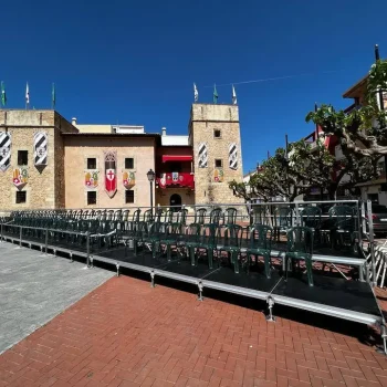 Edificio grande con una torre alta y numerosas gradas dispuestas para un evento.