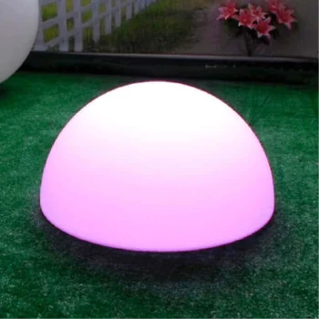 Media esfera de resina iluminada con luz LED, situada sobre un área de césped verde.