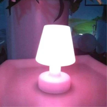 Lámpara de resina con luz LED rosa, emitiendo un suave resplandor en un entorno oscuro.