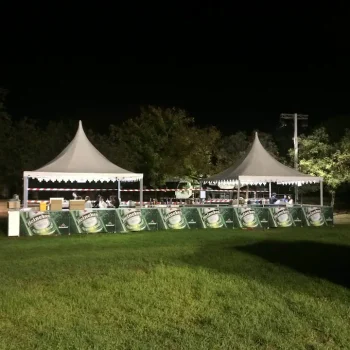 Carpa iluminada para un festival de cerveza, con luces brillantes y ambiente festivo en la noche.