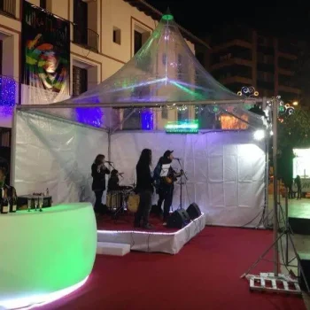 Escenario dentro de una carpa, con una banda actuando y un público disfrutando de la música.
