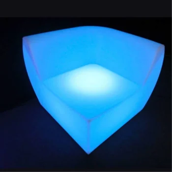Sofá de resina iluminado con luz LED, diseñado para eventos, ubicado en una esquina.