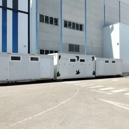 Módulo de WC blanco situado frente a un edificio.