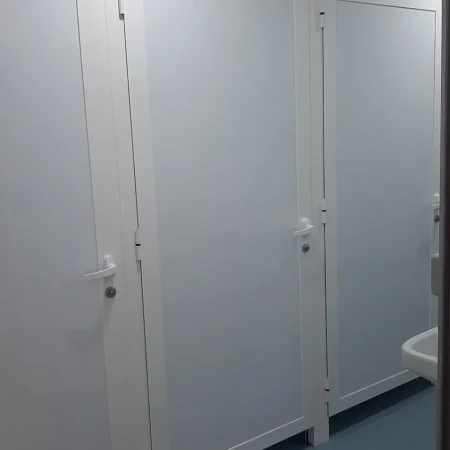 Baño con cuatro puertas blancas y un lavabo, mostrando un diseño funcional y ordenado.
