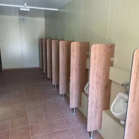 Fila de urinarios en un módulo de WC’s, con paredes y divisores entre cada uno.