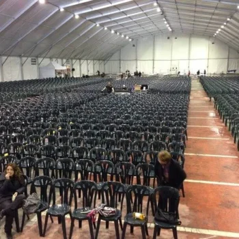 Carpa grande con mesas y sillas dispuestas en su interior, lista para un evento o reunión.