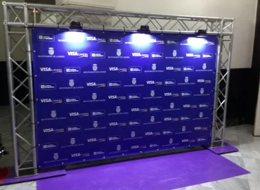 Photocall con un fondo púrpura iluminado por luces azules y blancas, creando un ambiente festivo.