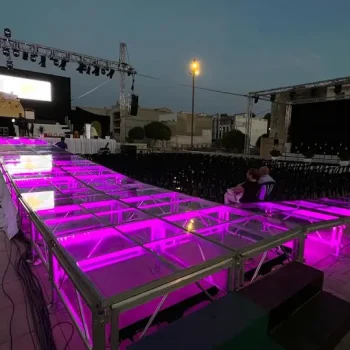 Escenario decorado con luces púrpuras, preparado para un evento o actuación en vivo.
