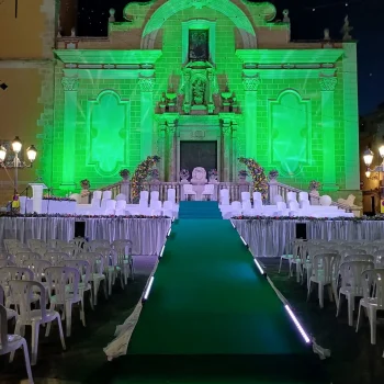 Escenario con sillas alineadas y luces verdes que iluminan el ambiente festivo.