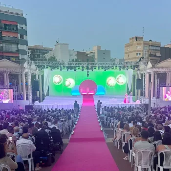 Multitud de personas reunidas frente a un escenario, disfrutando de un evento en vivo.