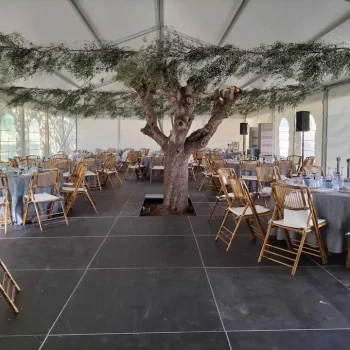 Carpa amplia con mobiliario preparado para un evento social o reunión.