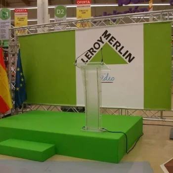 Tarima verde con un podio en el centro, lista para un evento de la empresa Leroy Merlin.