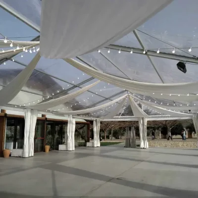 Carpa con tela blanca y luces colgantes en el techo, creando un ambiente iluminado y acogedor.