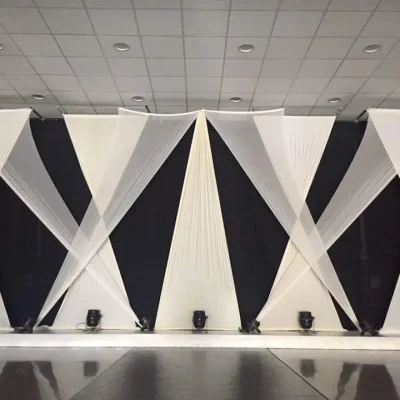 Escenario con cortinas elásticas blancas, en un ambiente en blanco y negro.