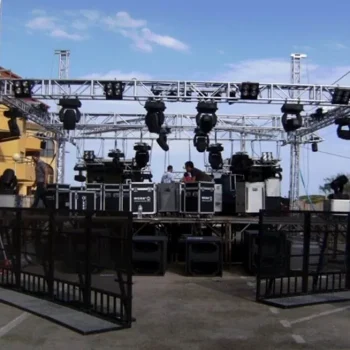 Valla de aluminio en un escenario con luces y altavoces preparados para un evento.