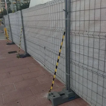 Valla de aluminio en construcción al lado de un edificio, mostrando el proceso de instalación.