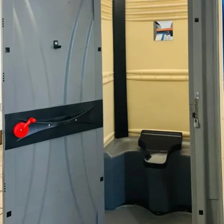 Inodoro químico portátil con la puerta abierta, mostrando el interior y su diseño funcional.