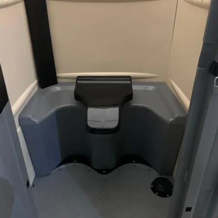 Inodoro químico portátil con tapa y asiento, diseñado para uso en exteriores y eventos.