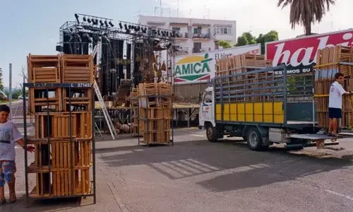 Camión en la calle cargado de cajas y materiales, preparándose para la producción de un evento.